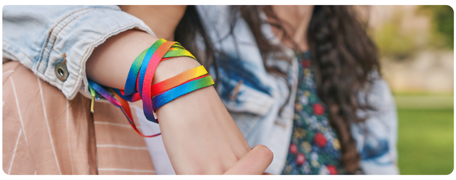 Mulher com pulseira nas cores da bandeira LGBTQIAPN+